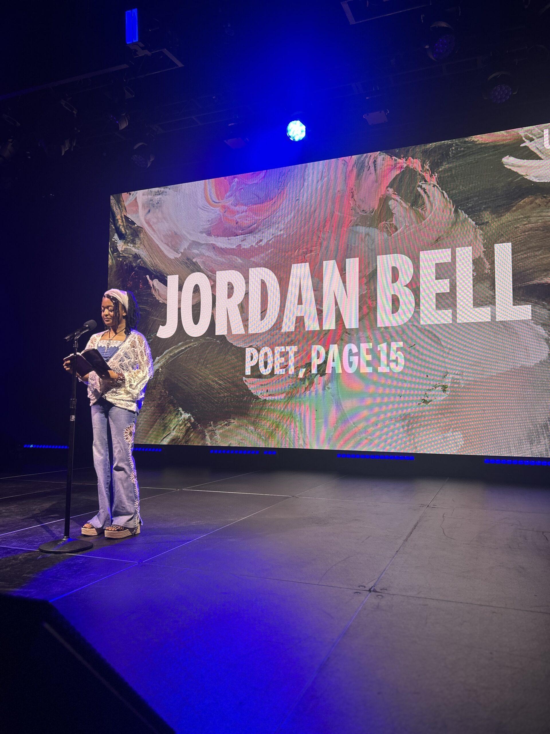 Young poet reading their poem to an audience